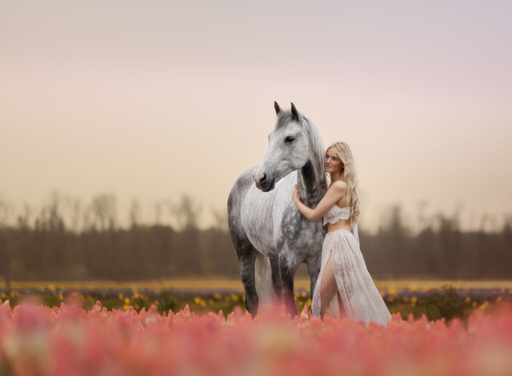 Mädchen mit Apfelschimmel im Tulpenfeld im Sonnenaufgang in Holland